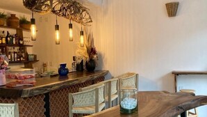 Una cucina moderna con una penisola in legno, sgabelli da bar, illuminazione a sospensione e una ventola a soffitto.