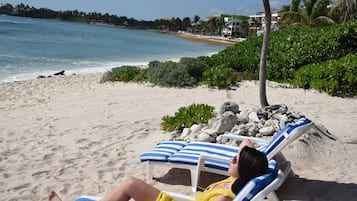 Aan het strand, wit zand, ligstoelen aan het strand, strandlakens