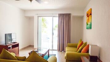 Condo, 2 Bedrooms (Beachfront, 1 Bathroom) | Living area | Flat-screen TV