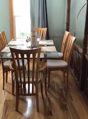 A dining area with a glass table, wooden chairs, and a wooden floor. - Come to where the colors surround you!Gorgeous Country and water Views, tranquil (Williamsburg)