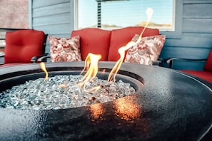 A fire pit with flames, surrounded by red furniture and patterned cushions. - `Off Road Retreat`  Moab (Moab)