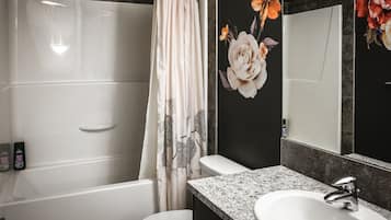A bathroom with a shower, a sink, and a mirror.