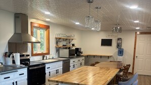 Eine moderne Küche mit einer zentralen Kochinsel, Edelstahlgeräten und Holzboden.