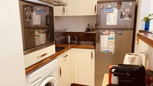 A compact kitchen with a washing machine, a sink, and a refrigerator. - Large studio in Cannes-MON2 (CANNES)