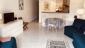 A modern living room with a TV, sofa, and dining area with chairs and a table. - Large studio in Cannes-MON2 (CANNES)