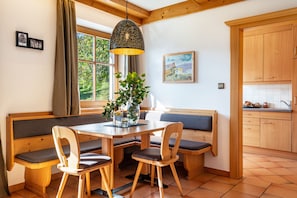 Un espace repas avec des bancs en bois, une table et un luminaire suspendu.