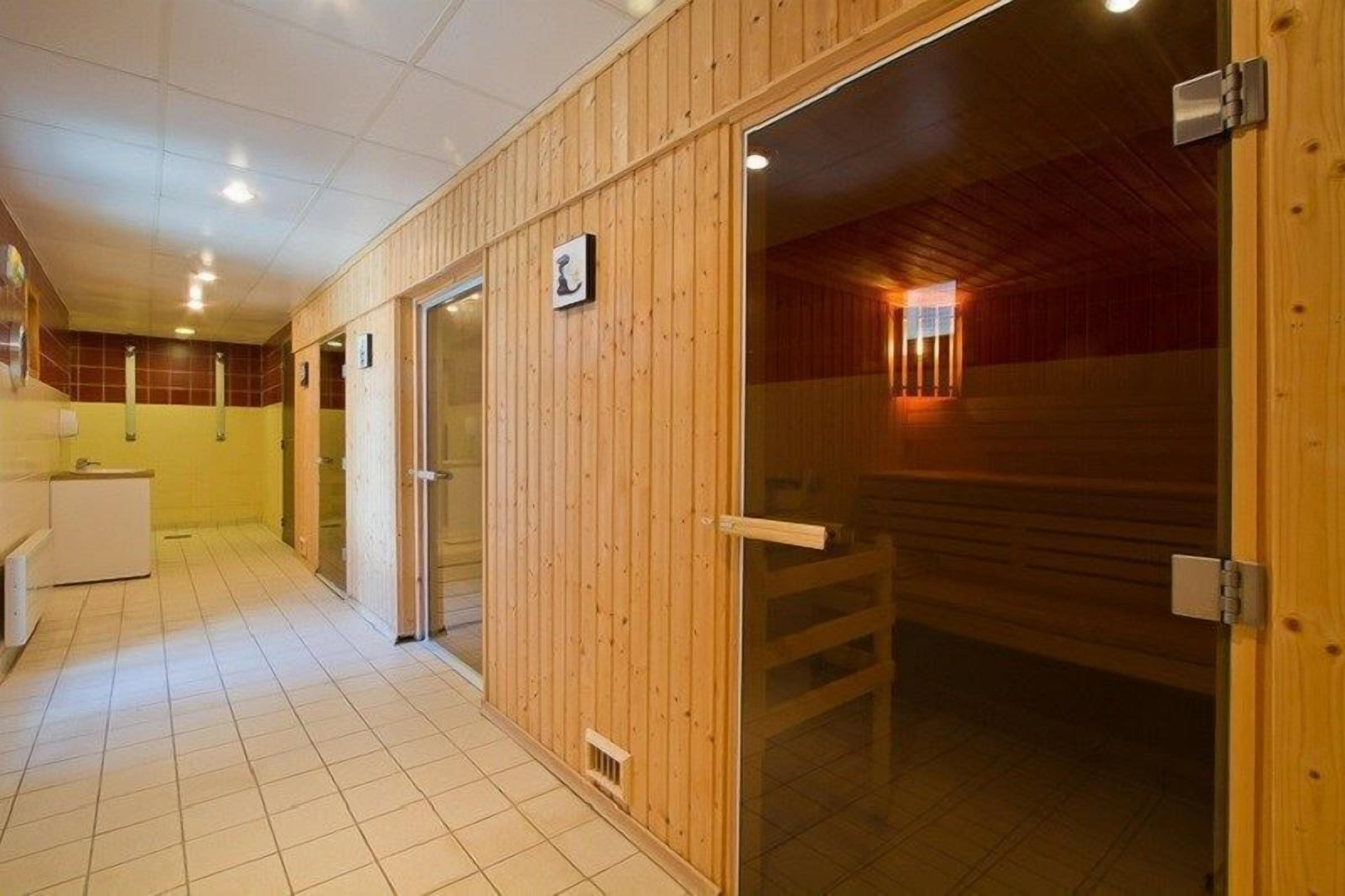 A sauna room with wooden walls and a tiled floor.