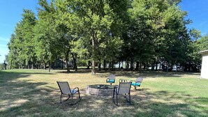 A grassy outdoor area with two metal chairs and a fire pit. - Cute cabin in nice quiet secluded area close to the water, The Coves Golf course (Afton)