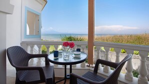 Un balcon avec une table, des chaises et une vue sur la plage.