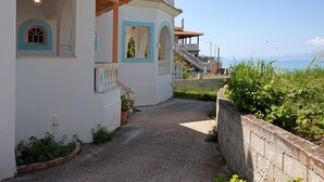 Un bâtiment avec un chemin de gravier, un balcon doté d’une balustrade et une vue sur la mer.