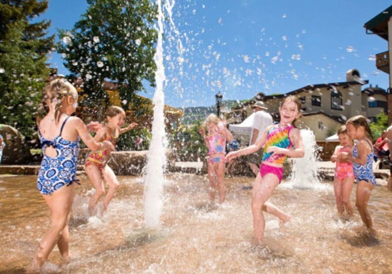 Een groep mensen die in een waterfontein speelt.