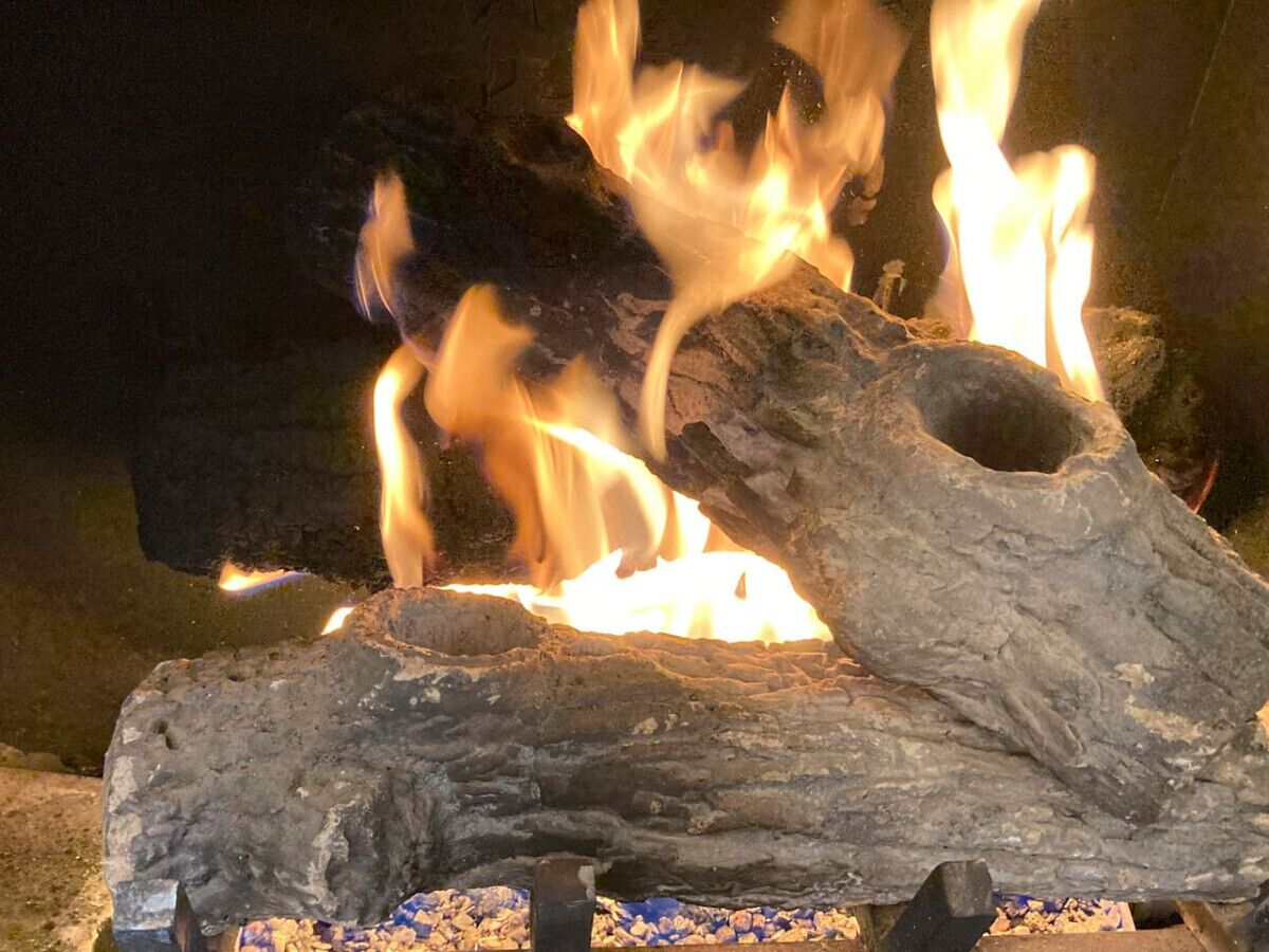 A close-up of a fire burning in a fireplace with logs.