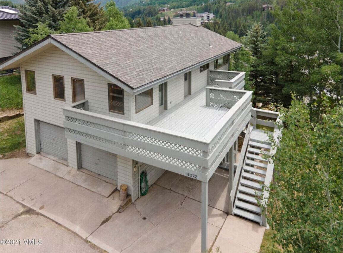 A two-story house with a balcony, a garage, and a number '2572' on the front.