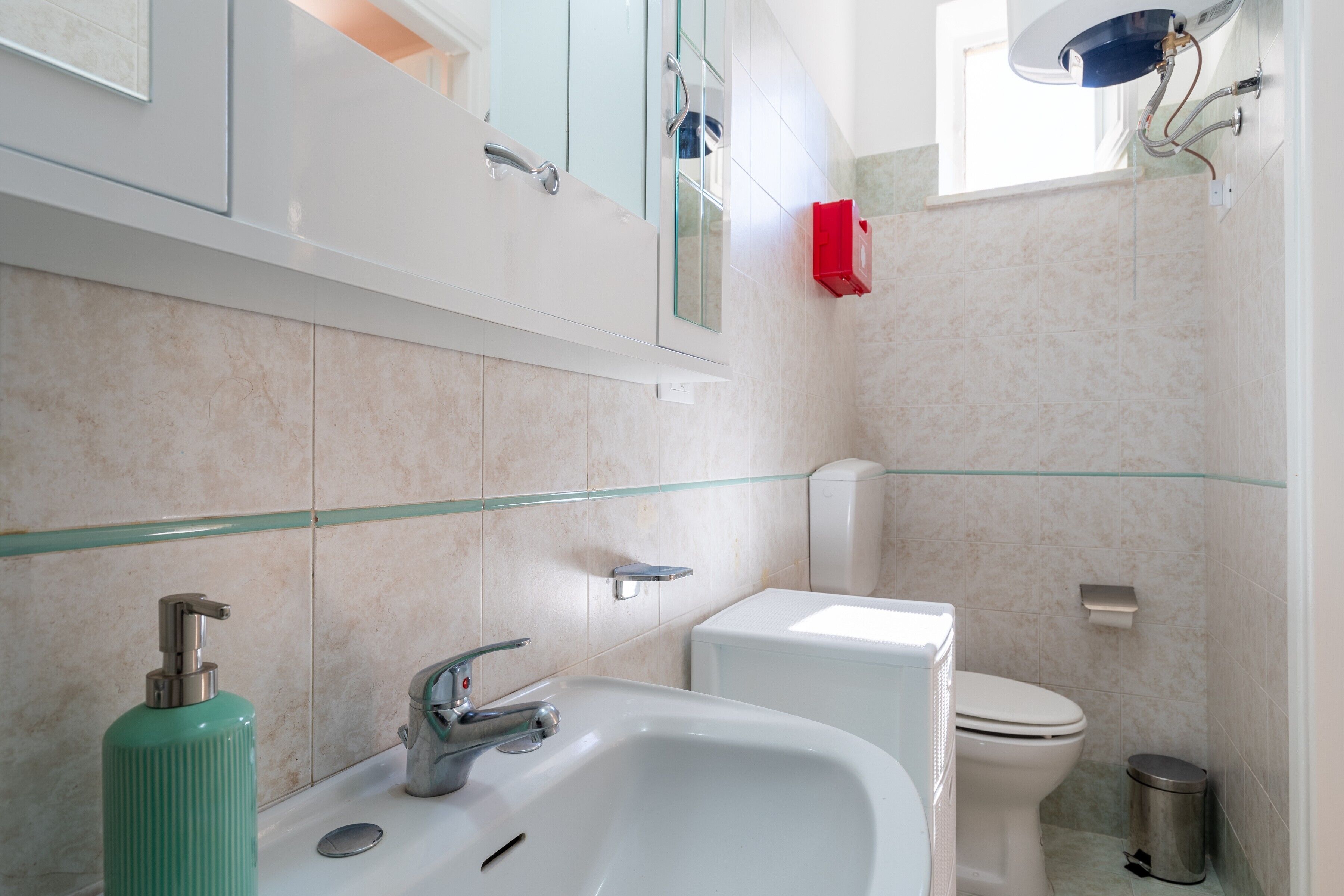 Une salle de bain avec un lavabo blanc, des toilettes et une cabine de douche en verre.