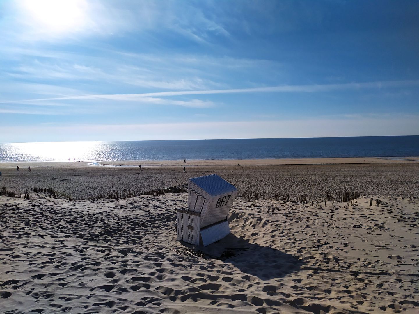 A beach with a sandcastle labeled "867" and a clear view of the ocean.