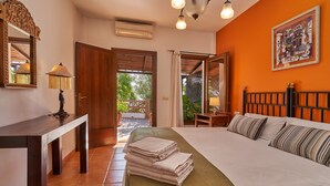 A hotel room with a bed, a desk, a mirror, a lamp, and a view of the outdoors.