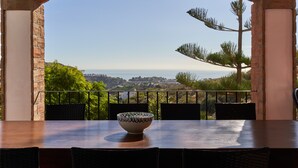 A dining table with a bowl, chairs, and a view through an archway.