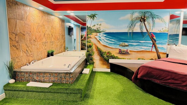 A bathroom with a large bathtub, a shower, and a mural of a beach scene. - Inn of The Dove Harrisburg-Hershey Romantic Suites (Harrisburg)