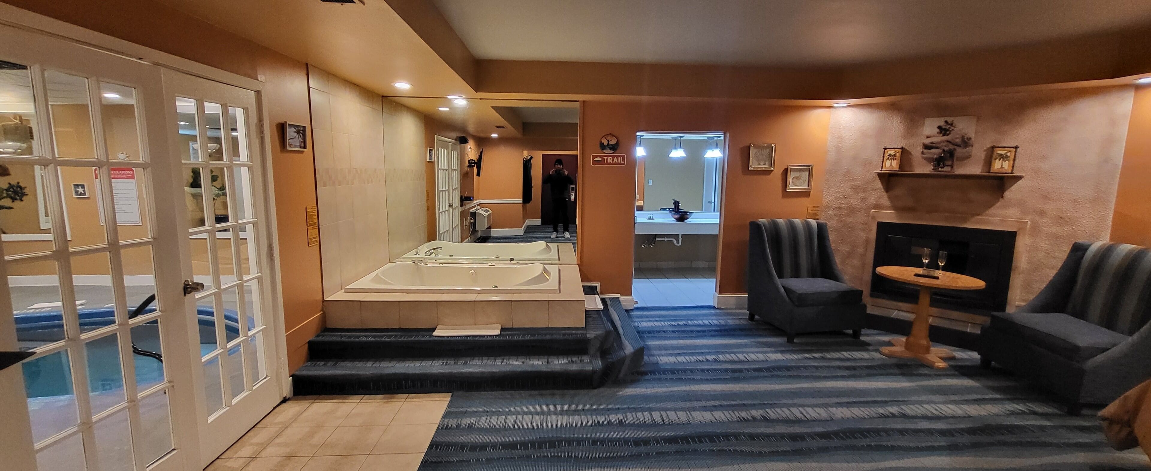 Eine Hotlellobby mit einer großen Badewanne, einem Kamin und einer Sitzecke.