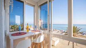 A balcony with a view of the beach, a table with a bottle and a glass, and two white chairs. - Estudio Medayra by Solset (Torrox)