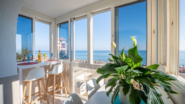 A balcony with a view of the sea, a table with chairs, and a potted plant. - Estudio Medayra by Solset (Torrox)