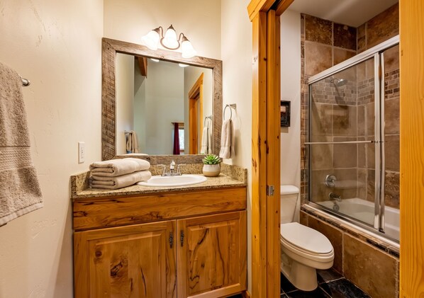A full bathroom with tiled shower-tub combo.