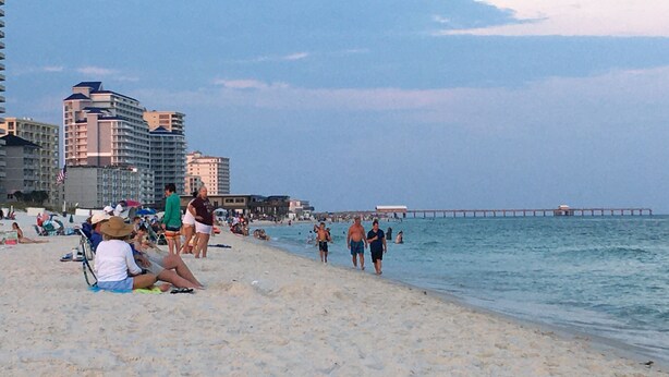 A beach with people, a pier, and buildings in the background. - Tiny for Two + Small Dog OK! -  Near BEACH, SPORTS COMPLEX, OWA, TANGER (Foley)