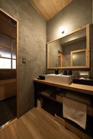 A modern bathroom with a wooden vanity, a large mirror, and a white sink. - Yoichi LOOP (Yoichi)