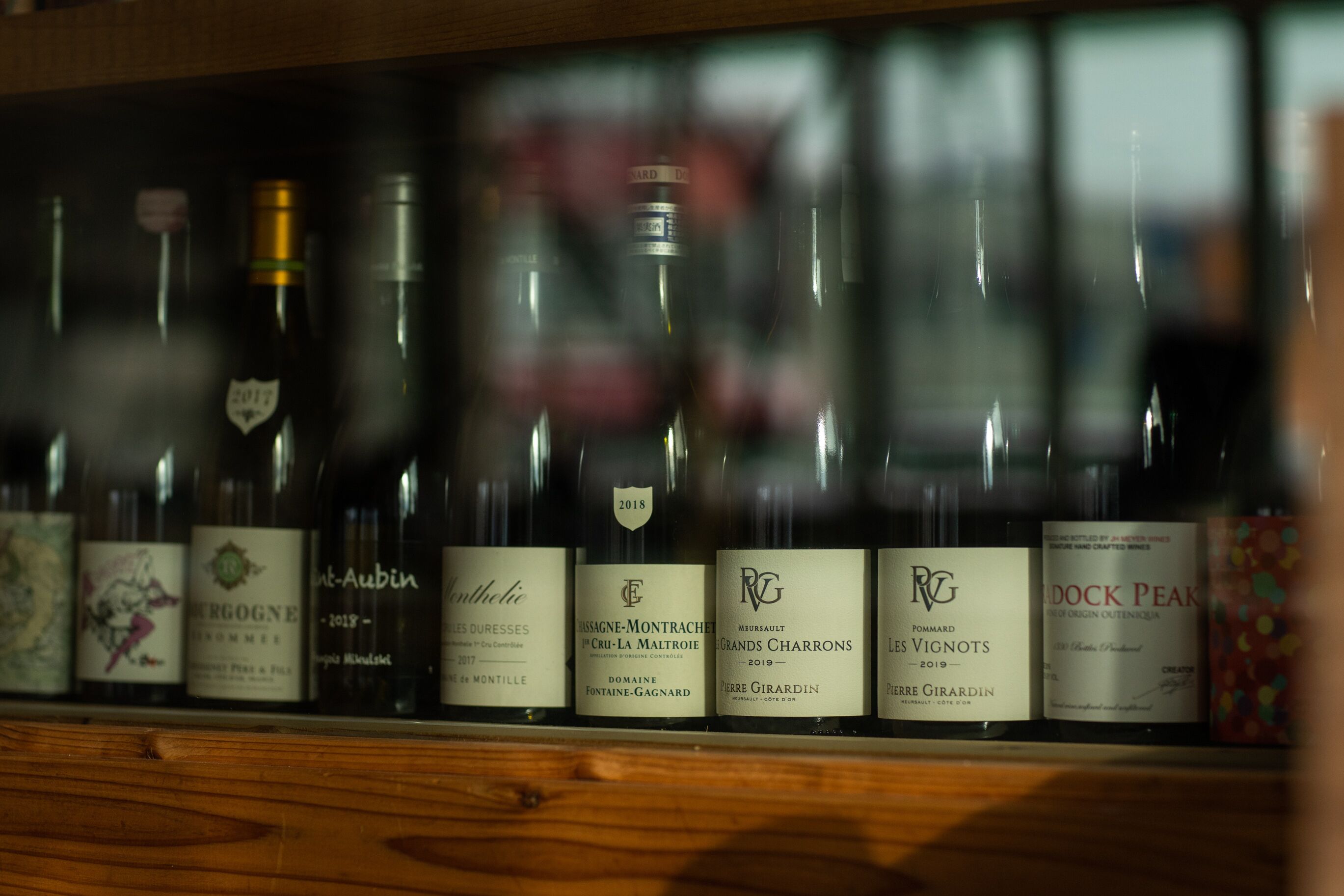 A row of wine bottles with labels, some featuring the year 2018.