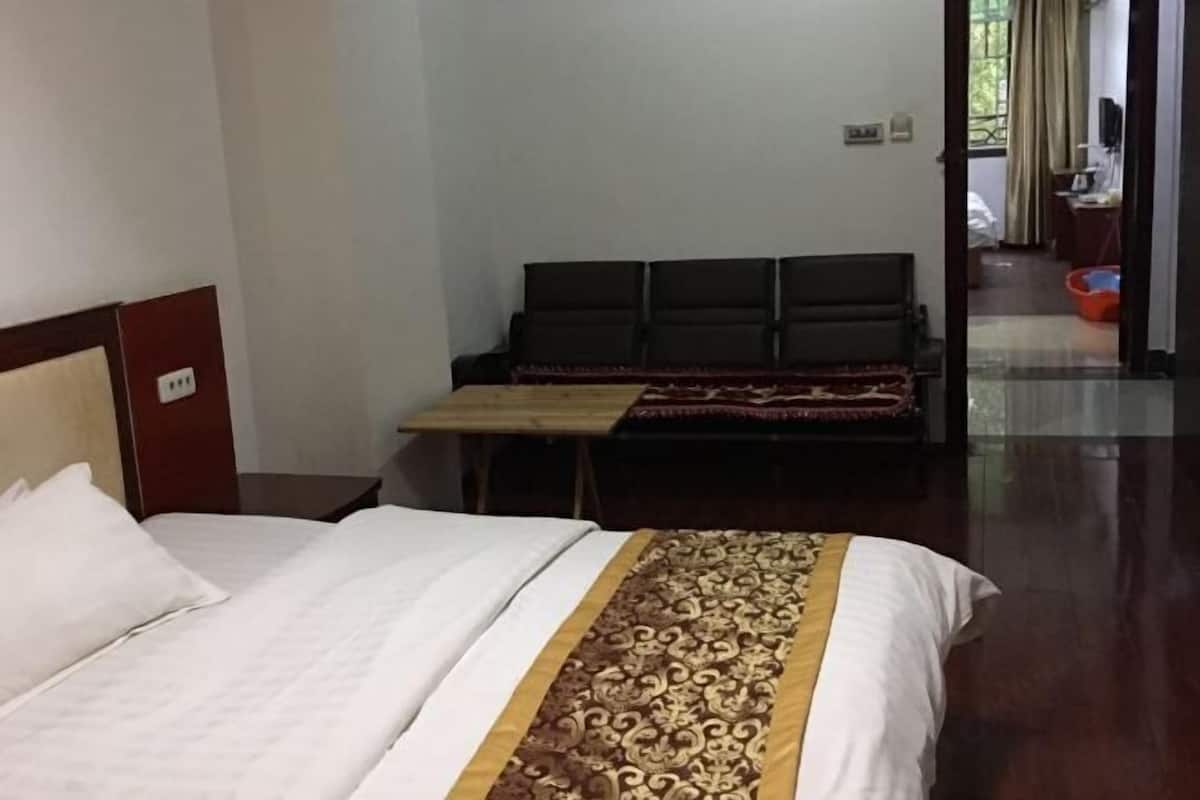 Une chambre d’hôtel avec un lit, une petite table et un canapé.