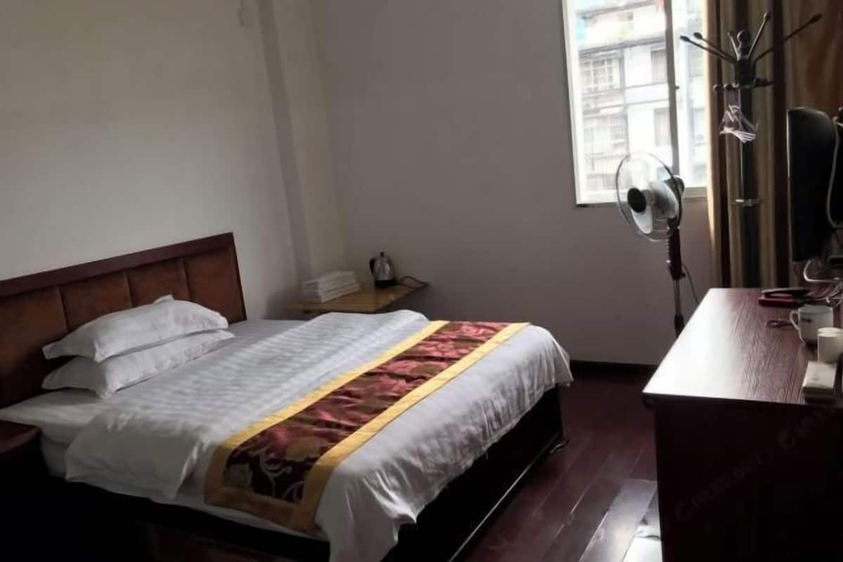 Une chambre à coucher comprenant un lit, une table de chevet et un bureau avec une chaise.