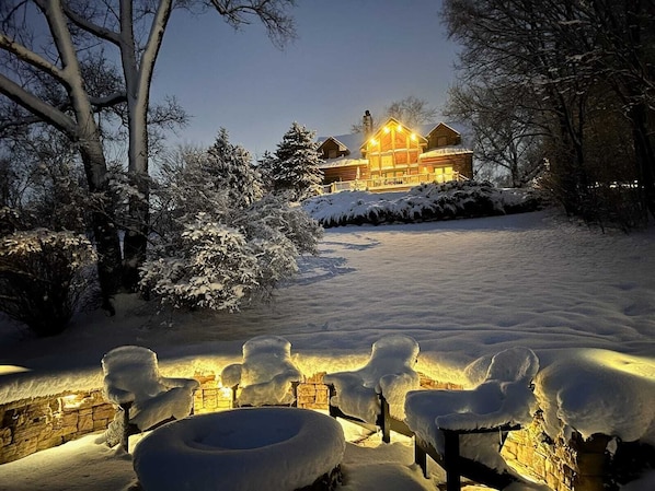 A snow-covered landscape with a wooden cabin and outdoor seating area. - Amazing cabin with private lake accesses (McHenry)