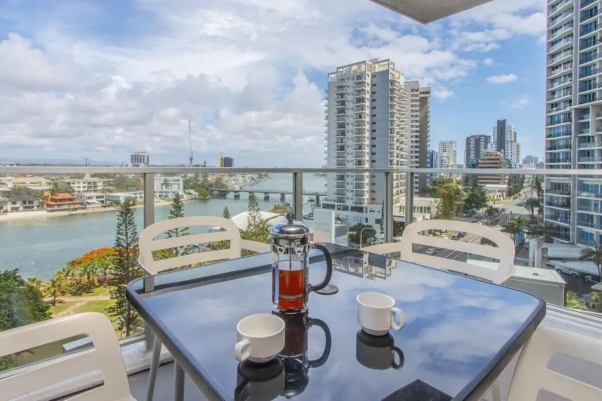 A balcony with a table, two chairs, and a coffee maker.