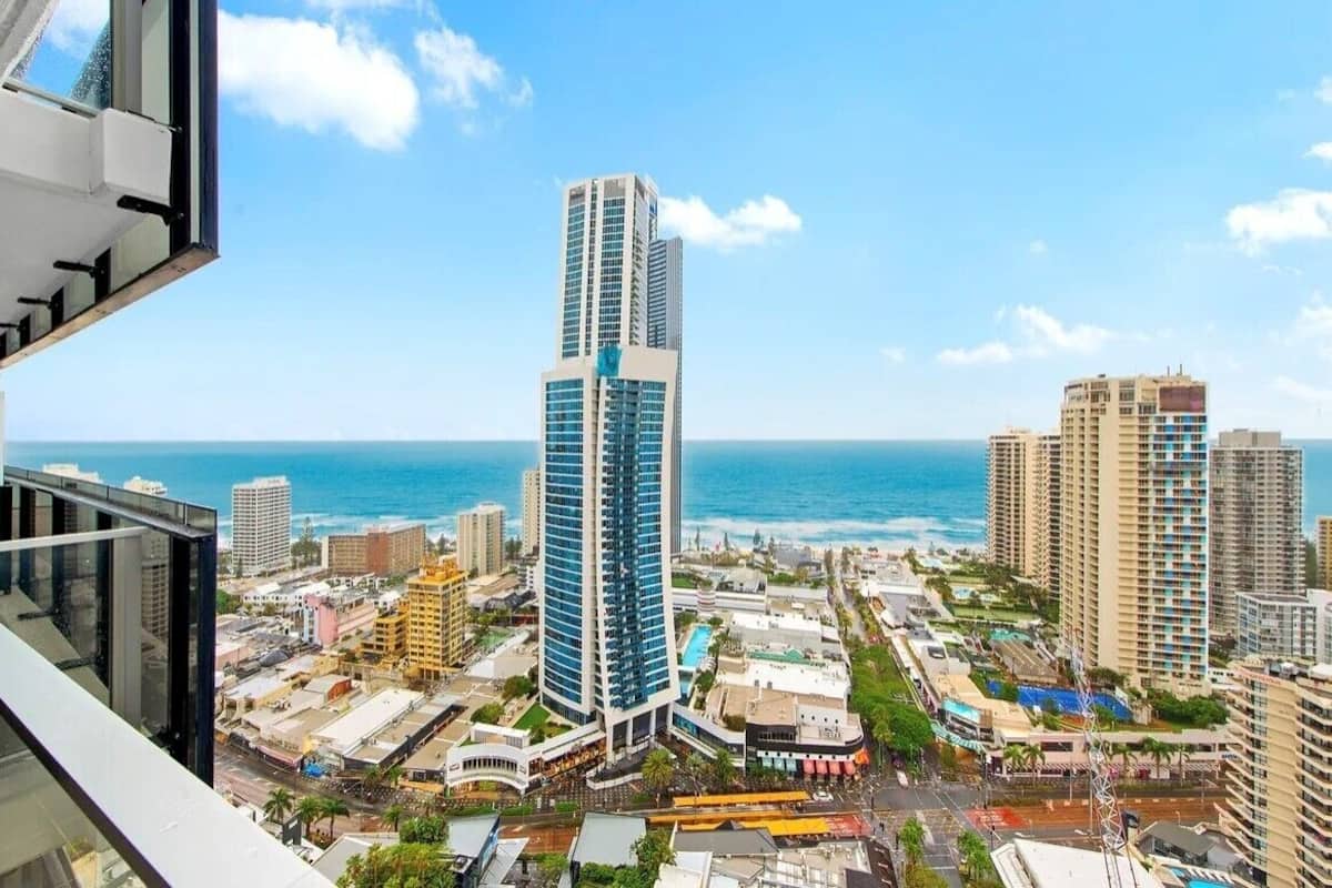 A high-rise hotel with a view of the ocean and other buildings.