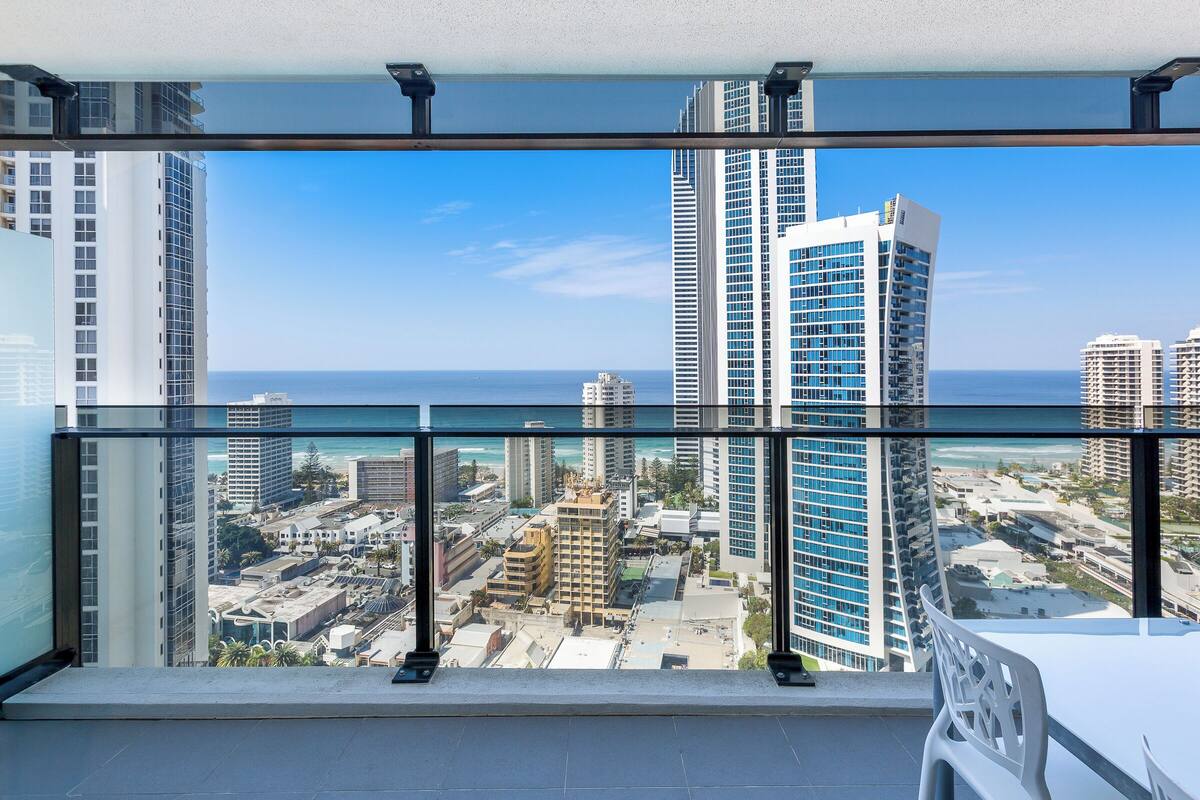 A high-rise building with a view of a cityscape and the ocean.