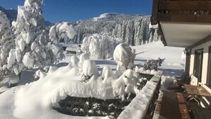 Un paysage enneigé avec un bâtiment dont la façade est en bois et qui possède un balcon.