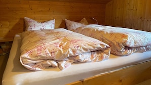 Un lit en bois avec une literie et des oreillers à motifs floraux.