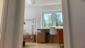 A room with a bed, a desk, a chair, and a window. - Holiday Home "Hofberg Villa" with Terrace, Open Garden and High-speed Wi-Fi (Landshut)