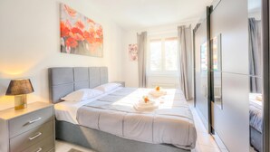 A modern bedroom with a bed, bedside lamp, and artwork on the wall. - Casa Rosa with Balcony in Lugano, Lugano, Switzerland (Lugano)