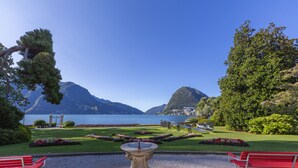 A garden with a fountain, benches, and a view of mountains and a lake. - Casa Rosa with Balcony in Lugano, Lugano, Switzerland (Lugano)