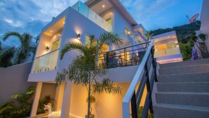 A modern two-story house with a balcony, stairs, and a satellite dish. - Elegant Designer 4BR Pool Villa Skylight (Kamala)