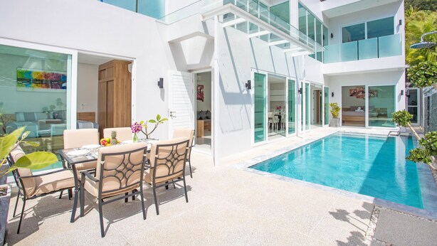 A modern house with a swimming pool, outdoor seating, and large windows. - Elegant Designer 4BR Pool Villa Skylight (Kamala)