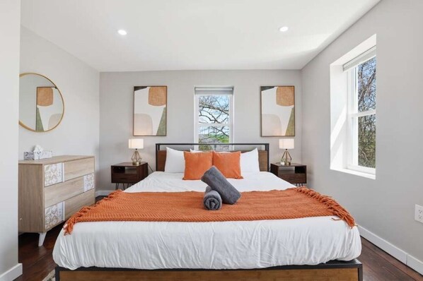 A bedroom with a large bed, two bedside tables, a dresser, and a window with a view. - Exclusive! Modern FarmHouse❖ + Pet-Friendly (Kunkletown)