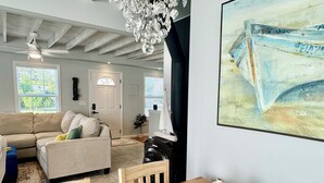 Un salon avec un canapé, une table à manger et un lustre.