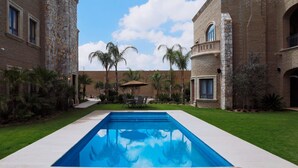 A pool with a stone wall on one side and a brick building on the other. - Hacienda los Arcangeles (San Miguel de Allende)