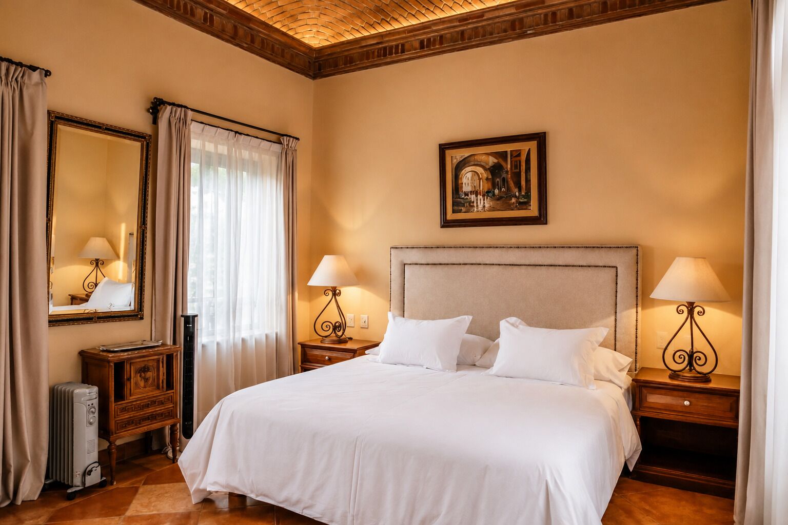 A hotel room with a large bed, two bedside tables with lamps, a large mirror, and a painting on the wall.