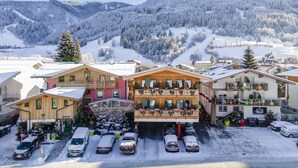 Un albergo con una seggiovia, circondato da montagne e alberi innevati.