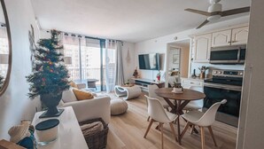 A modern apartment with a living area, dining space, kitchen, and a balcony with a Christmas tree. - Lovers Key: Amazing Views with private beach/pool! (Fort Myers Beach)