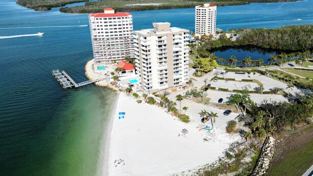 An aerial view of a coastal hotel with multiple buildings, a beach, and a pier. - Lovers Key: Amazing Views with private beach/pool! (Fort Myers Beach)