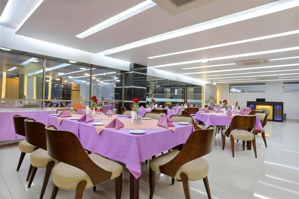 Un comedor moderno con mesas dispuestas para varios comensales, con un diseño limpio y contemporáneo y una paleta de colores neutra.